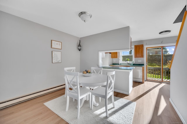 dining space with baseboard heating and light wood-type flooring