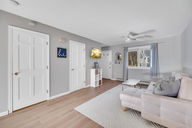 living room with ceiling fan, a baseboard radiator, and hardwood / wood-style flooring