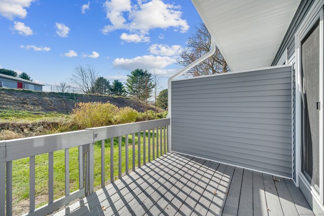 wooden deck featuring a lawn