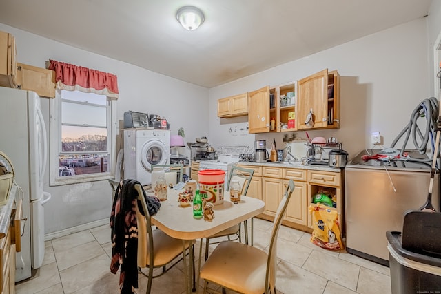 kitchen with white refrigerator, light tile patterned flooring, washer / clothes dryer, and light brown cabinetry