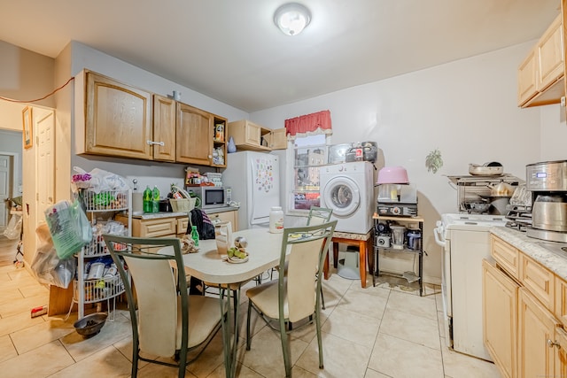 kitchen featuring white fridge, washer / dryer, range, and light brown cabinetry