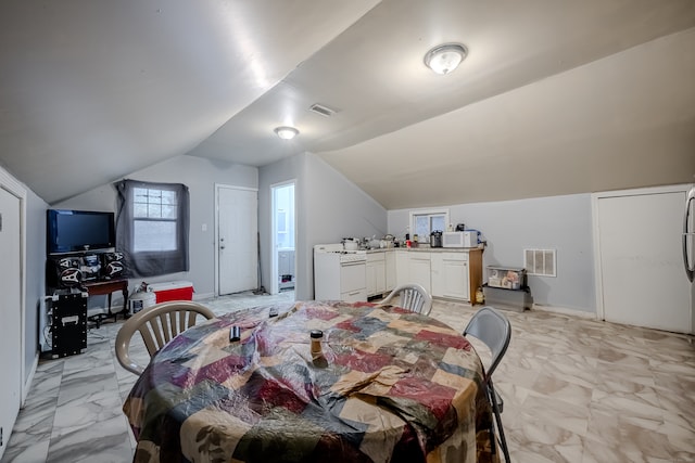 dining area featuring vaulted ceiling