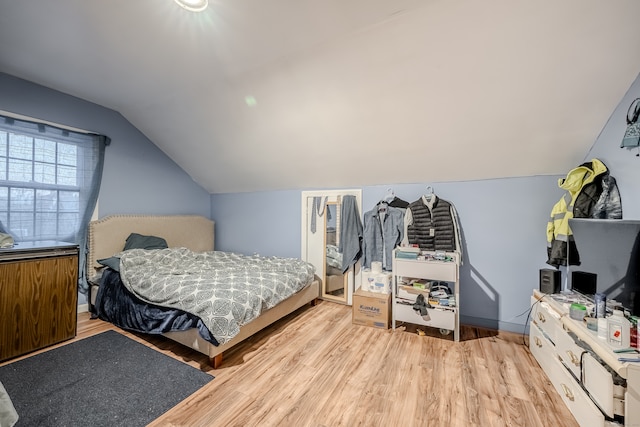 bedroom featuring light hardwood / wood-style floors and lofted ceiling