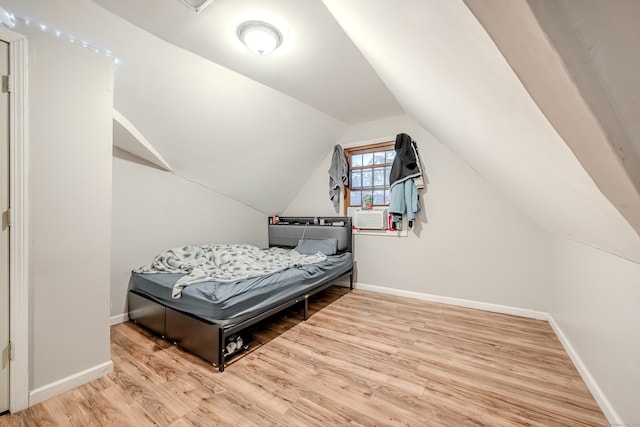 bedroom featuring vaulted ceiling and light hardwood / wood-style flooring