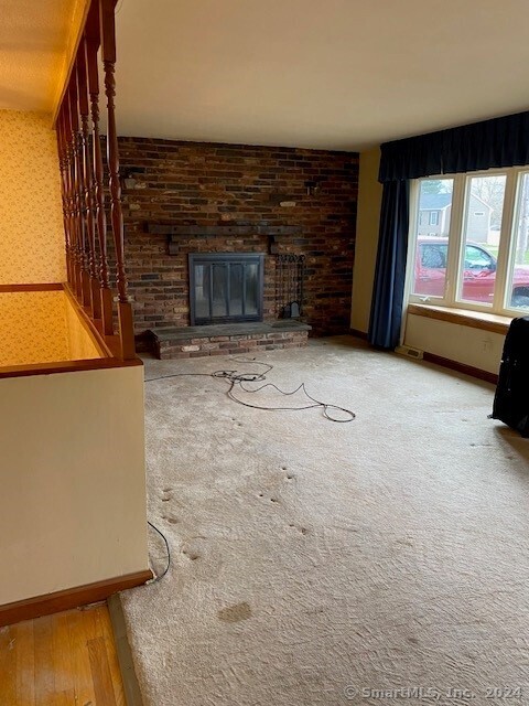 unfurnished living room featuring a brick fireplace