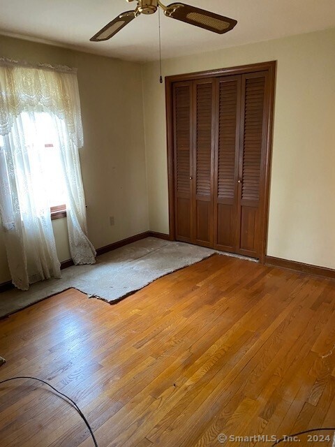 unfurnished bedroom with ceiling fan and light hardwood / wood-style flooring