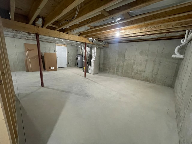 basement featuring heating unit and electric water heater