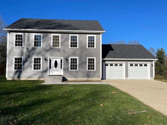 colonial-style house with a front yard and a garage