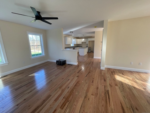 unfurnished living room featuring hardwood / wood-style flooring and ceiling fan