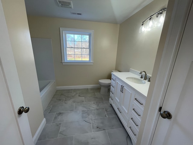 bathroom featuring vanity, toilet, and a tub