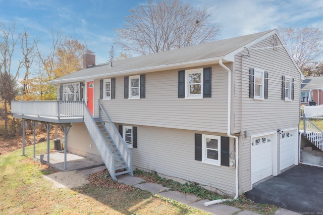 view of front of home featuring a garage, a deck, and central AC unit