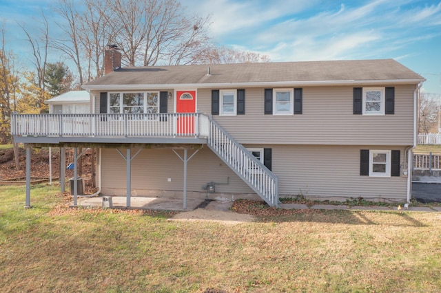 view of front of home featuring a front yard, central AC unit, a wooden deck, and a patio area