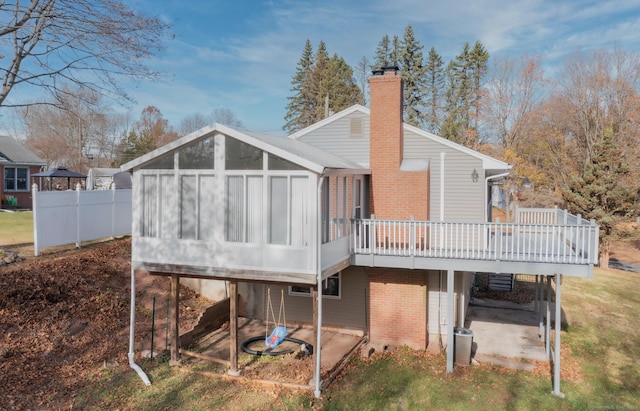 rear view of house featuring central air condition unit, a deck, and a sunroom