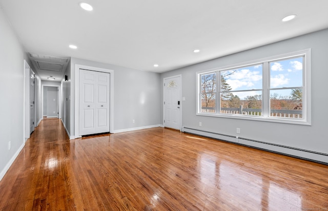 spare room featuring baseboard heating and wood-type flooring