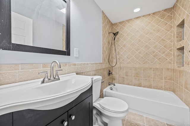 full bathroom with toilet, vanity, tile walls, and tiled shower / bath