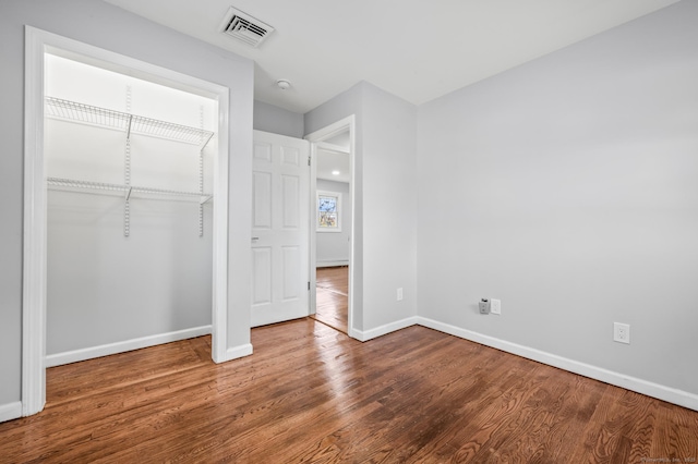 unfurnished bedroom featuring hardwood / wood-style floors and a closet