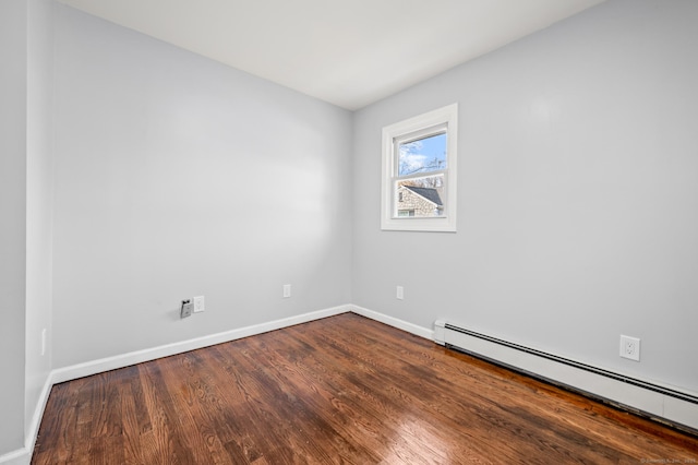 unfurnished room with a baseboard heating unit and hardwood / wood-style flooring