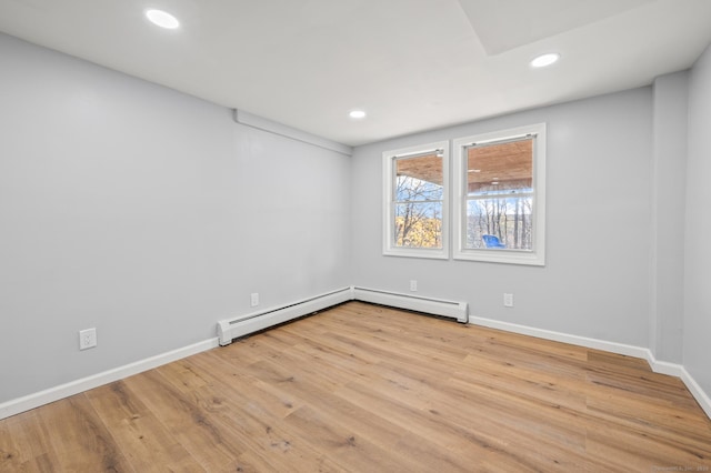 empty room with baseboard heating and light wood-type flooring