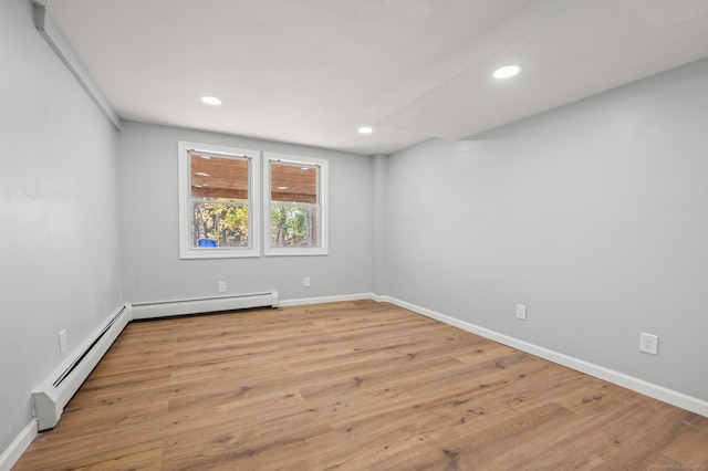 empty room featuring light hardwood / wood-style floors and a baseboard heating unit