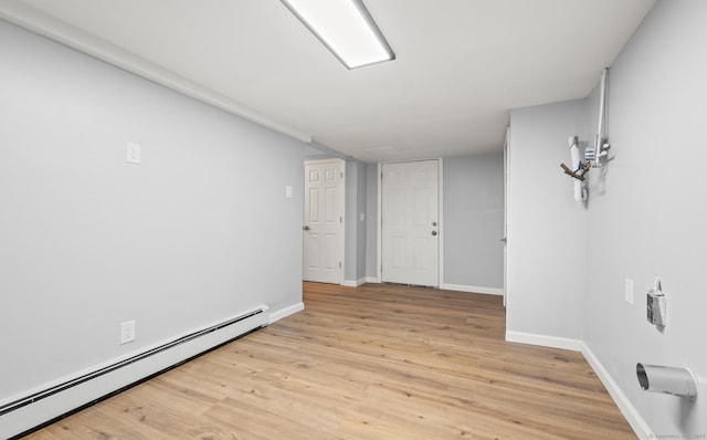 basement with a baseboard radiator and light hardwood / wood-style floors