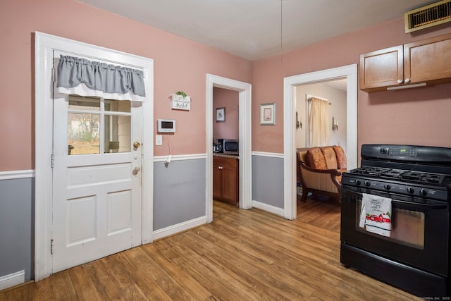 kitchen featuring black gas stove and light hardwood / wood-style flooring