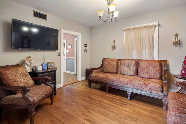 living room with a notable chandelier and light wood-type flooring