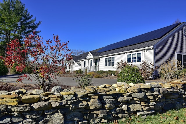 view of side of property featuring solar panels