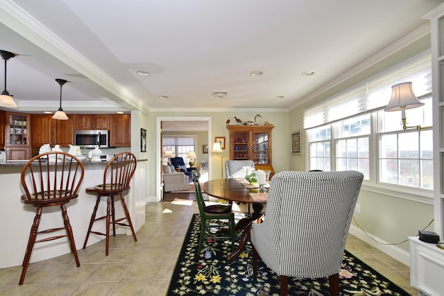 dining space featuring light tile patterned floors and ornamental molding