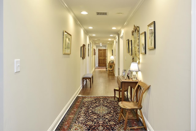 hallway featuring hardwood / wood-style floors and ornamental molding