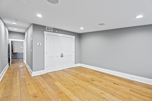 unfurnished bedroom featuring light hardwood / wood-style flooring and a closet