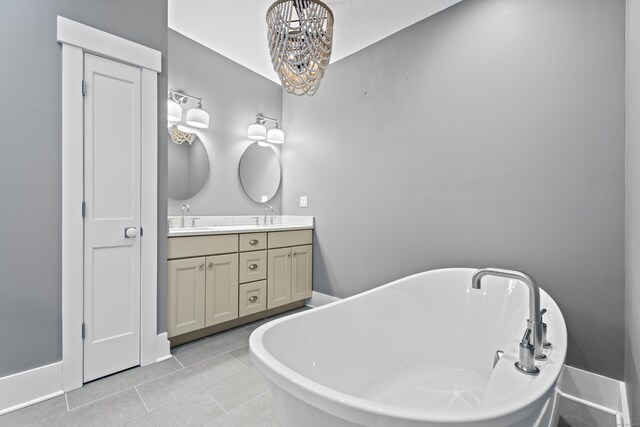 bathroom with vanity, a washtub, tile patterned floors, and a chandelier