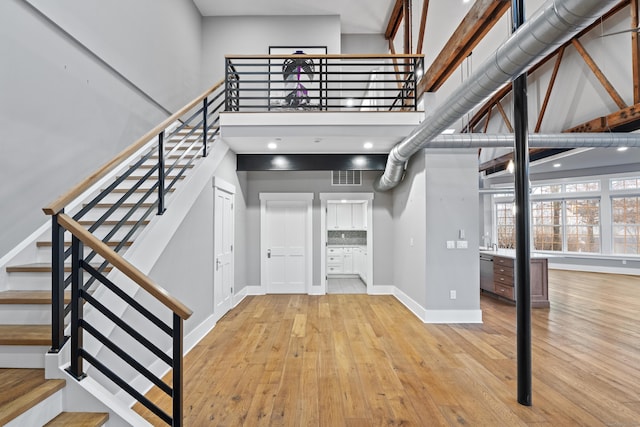 stairs featuring hardwood / wood-style flooring and a towering ceiling