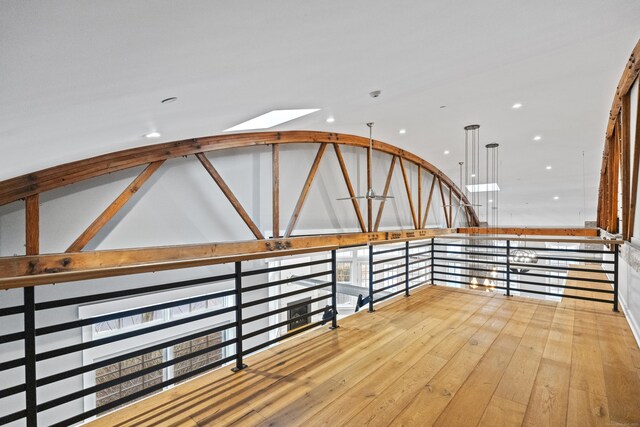 hallway featuring lofted ceiling and light wood-type flooring