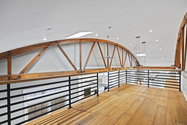 hall with vaulted ceiling and light wood-type flooring