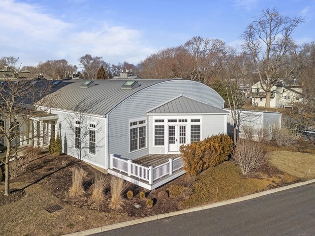 view of home's exterior featuring a wooden deck and french doors