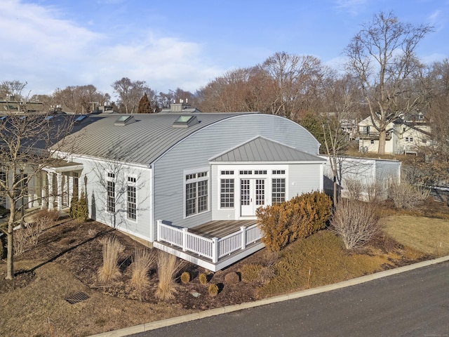 view of side of home featuring french doors and a deck