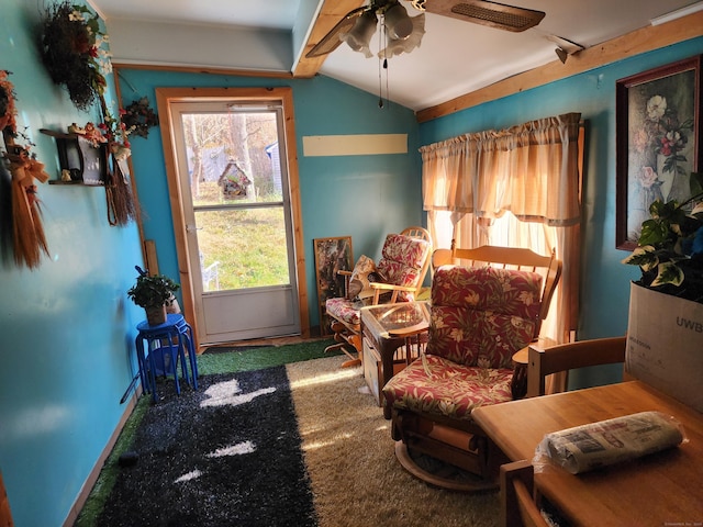 living area featuring carpet, plenty of natural light, lofted ceiling with beams, and ceiling fan