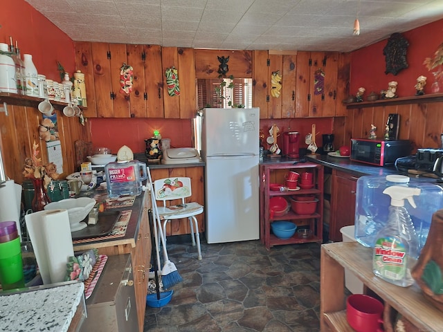 kitchen featuring wood walls and white fridge