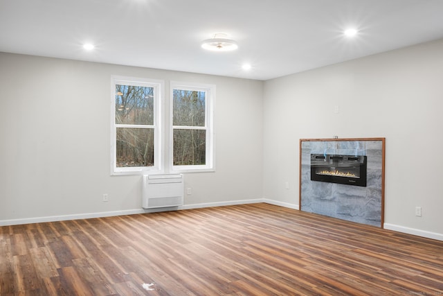 unfurnished living room featuring a tile fireplace and dark hardwood / wood-style flooring