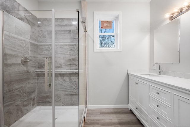 bathroom with hardwood / wood-style floors, vanity, and an enclosed shower