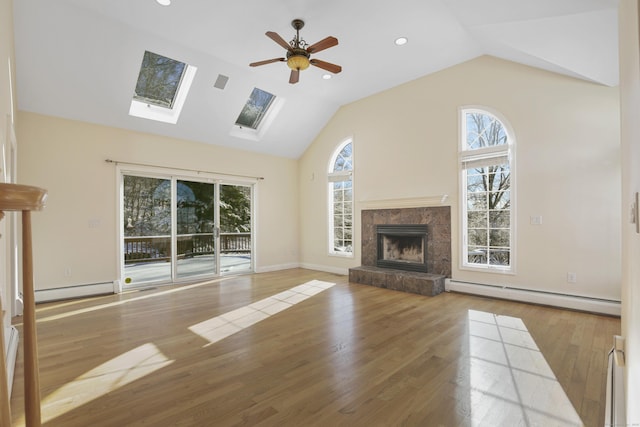 unfurnished living room with hardwood / wood-style flooring, a healthy amount of sunlight, and a baseboard heating unit