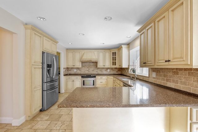 kitchen with kitchen peninsula, sink, custom range hood, and stainless steel appliances