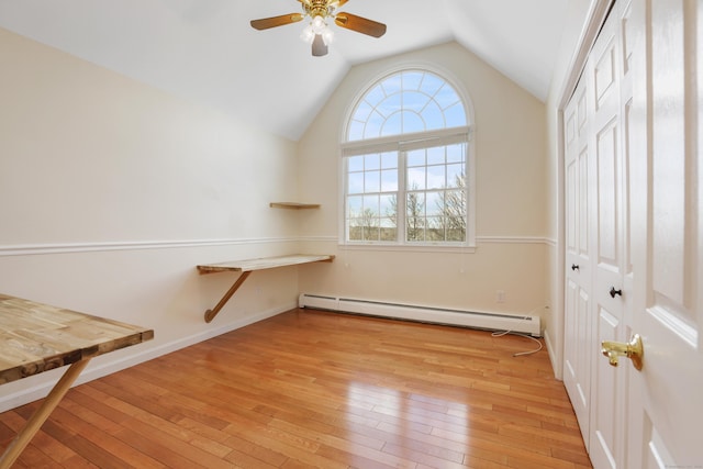 interior space with ceiling fan, baseboard heating, light hardwood / wood-style flooring, and lofted ceiling