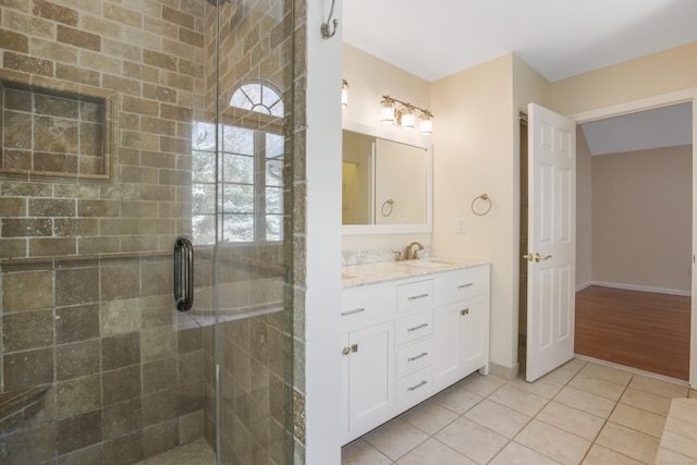 bathroom featuring tile patterned flooring, a shower with shower door, and vanity