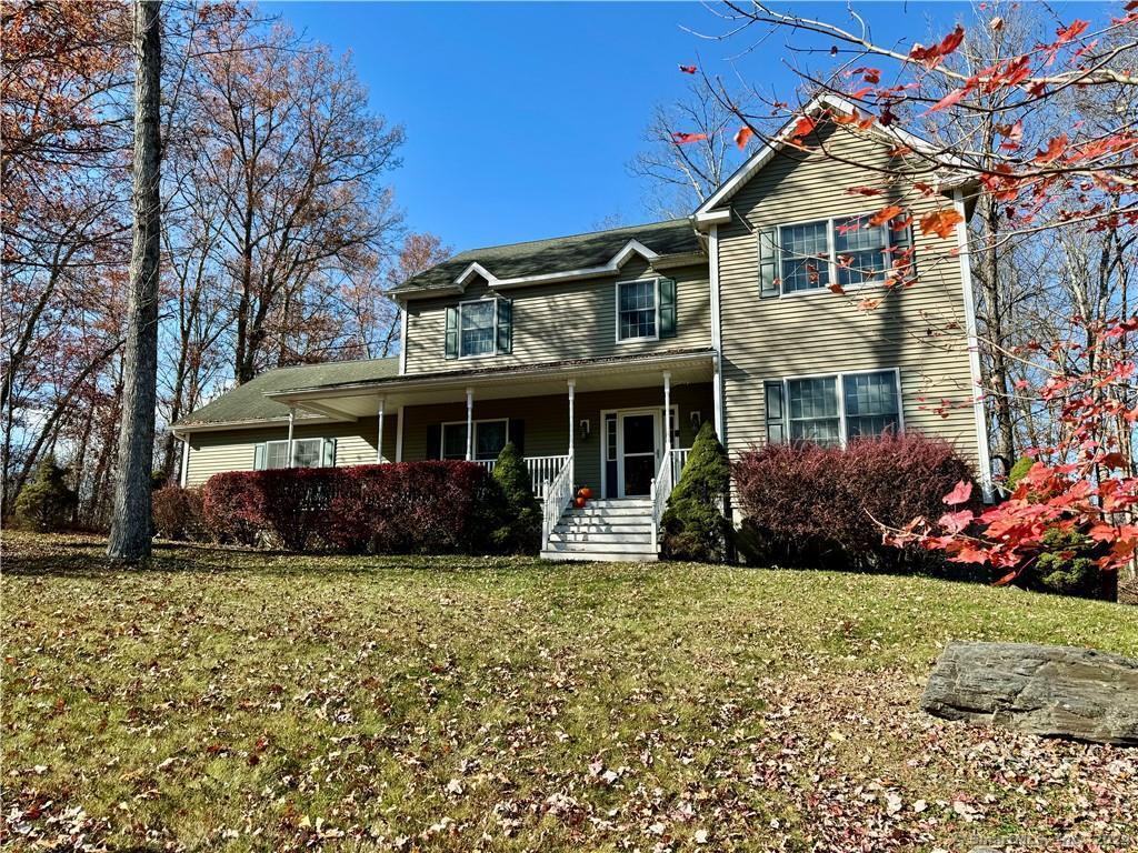 view of front of property featuring a front yard and covered porch