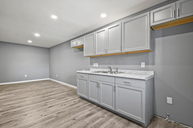 kitchen with light hardwood / wood-style flooring, gray cabinetry, and sink