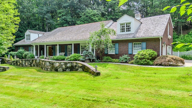 new england style home featuring a front lawn, a porch, and a garage