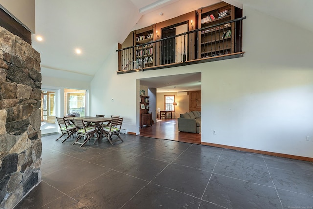 dining space featuring high vaulted ceiling