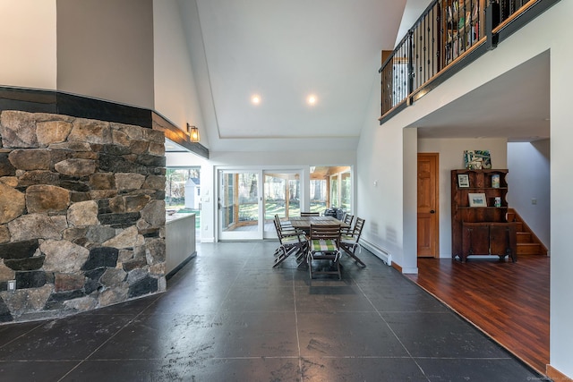 dining room featuring dark hardwood / wood-style floors, high vaulted ceiling, and a baseboard radiator