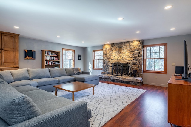 living room featuring a stone fireplace and hardwood / wood-style flooring